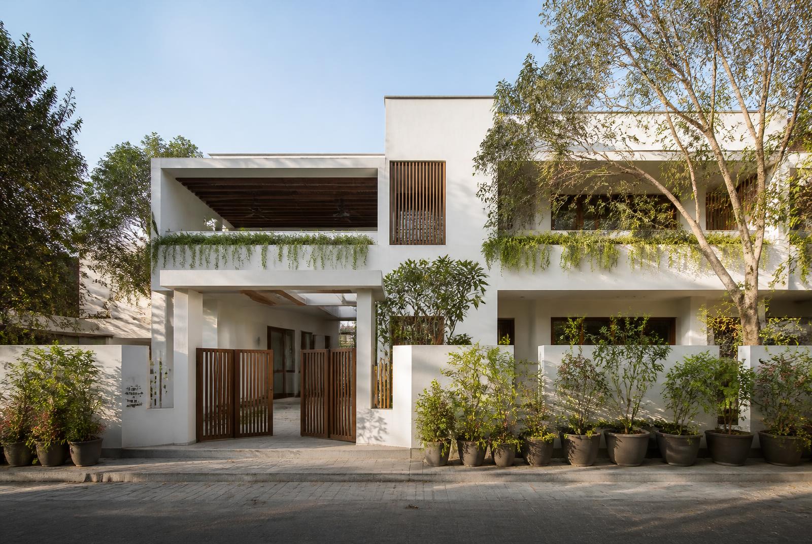 Residence facade with planted balconies and a pot-lined boundary
