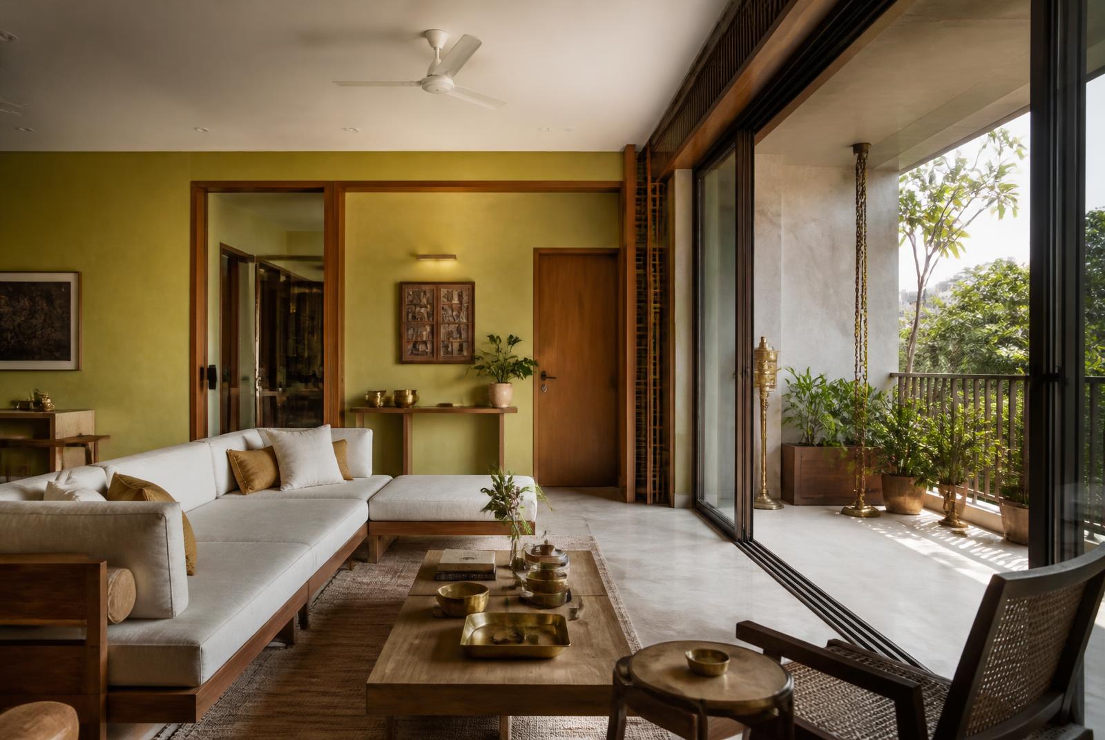 Living room opening onto a planted terrace through full-height glass